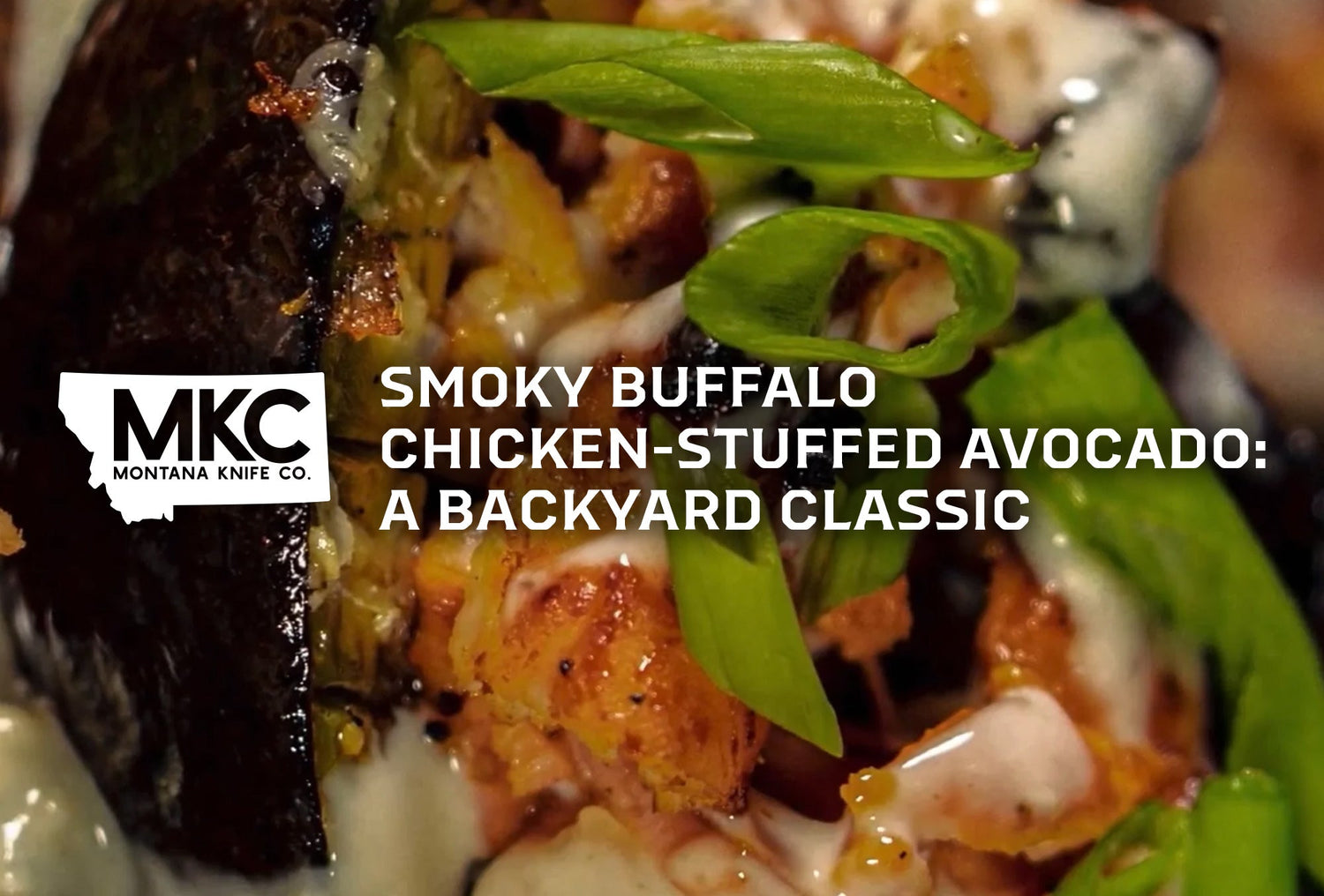 Close-up of a smoky buffalo chicken-stuffed avocado topped with chopped green onions and drizzled with creamy sauce.