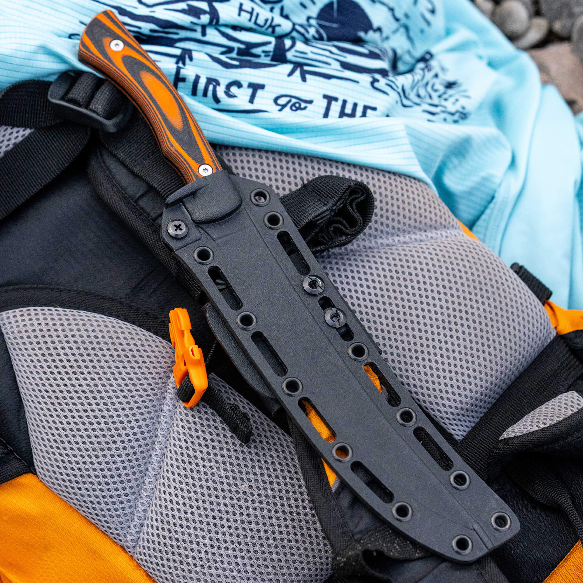 HUK Flathead Fillet knife resting on a backpack, showcasing its durable design and ergonomic handle.