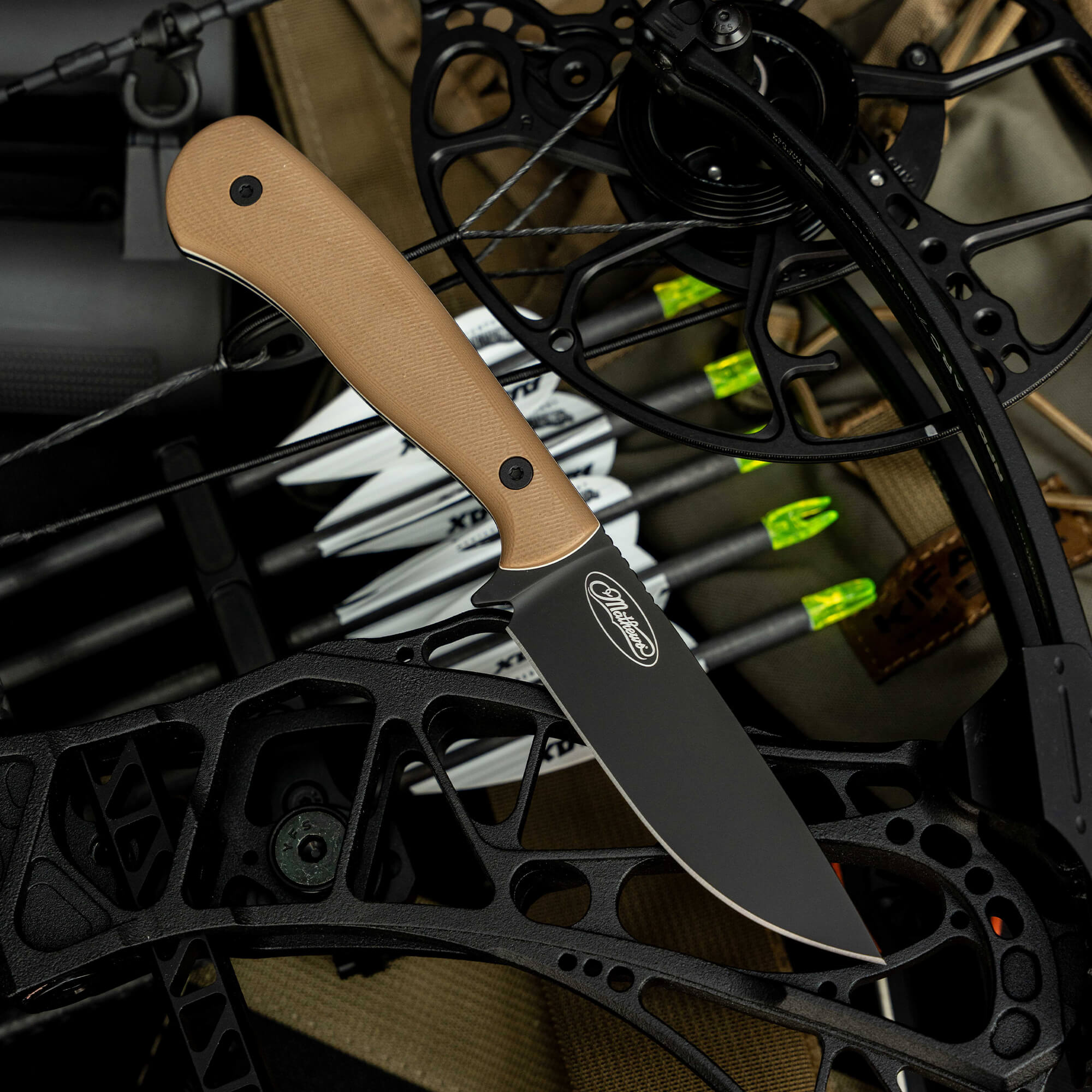 Mathews Archery MKC Whitetail knife on a bow setup, featuring a sleek black blade and tan handle, ideal for hunters.