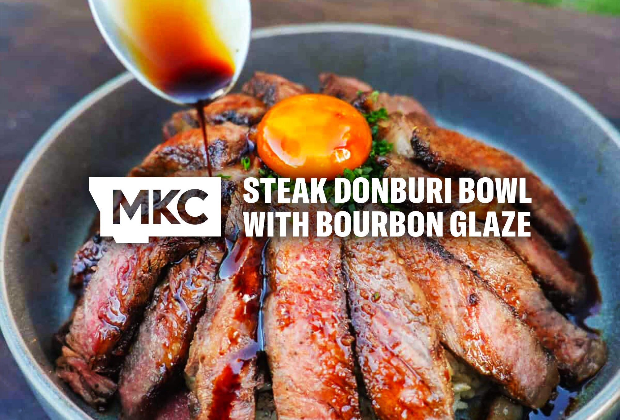 Sliced steak topped with egg yolk and garnish with a bourbon glaze being spooned on top for a steak donburi dish.