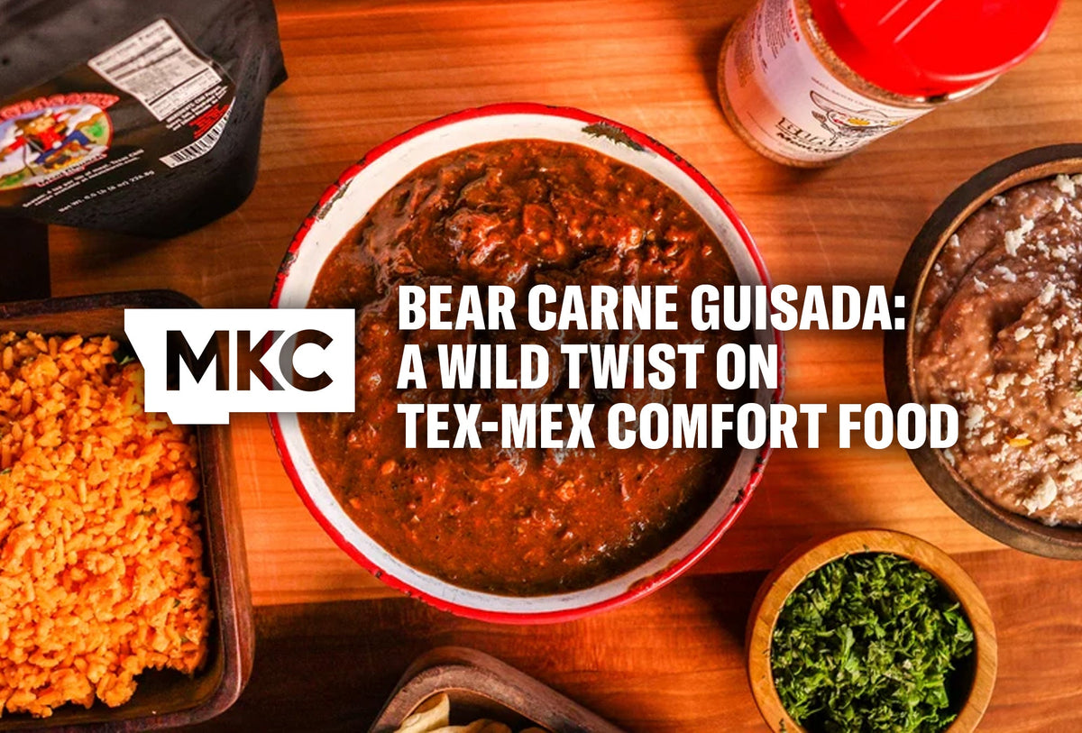 Bowl of bear carne guisada stew with Mexican rice, refried beans, and cilantro on a wooden table.