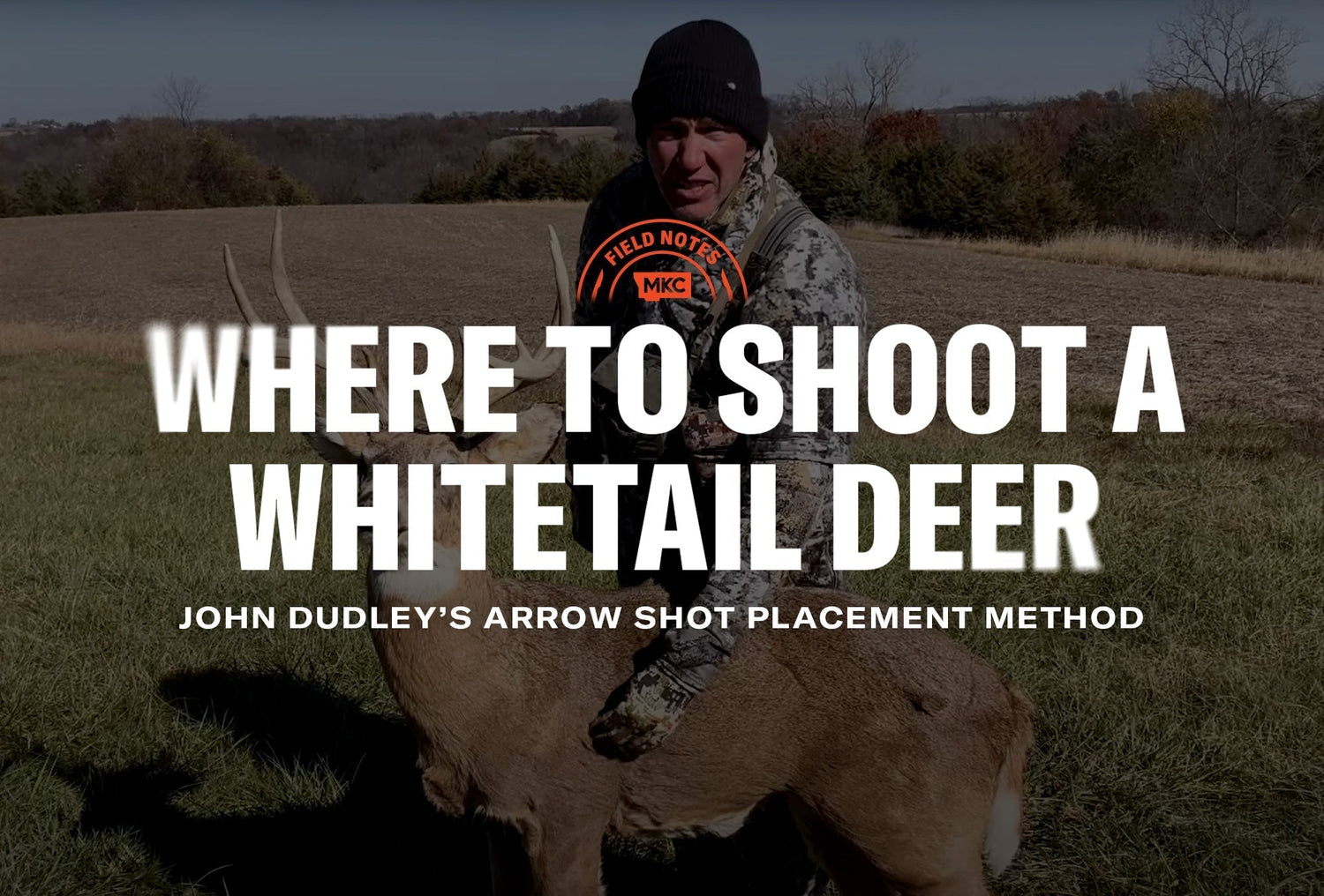 Hunter with a whitetail buck in a field, illustrating where to shoot a whitetail deer for proper shot placement.