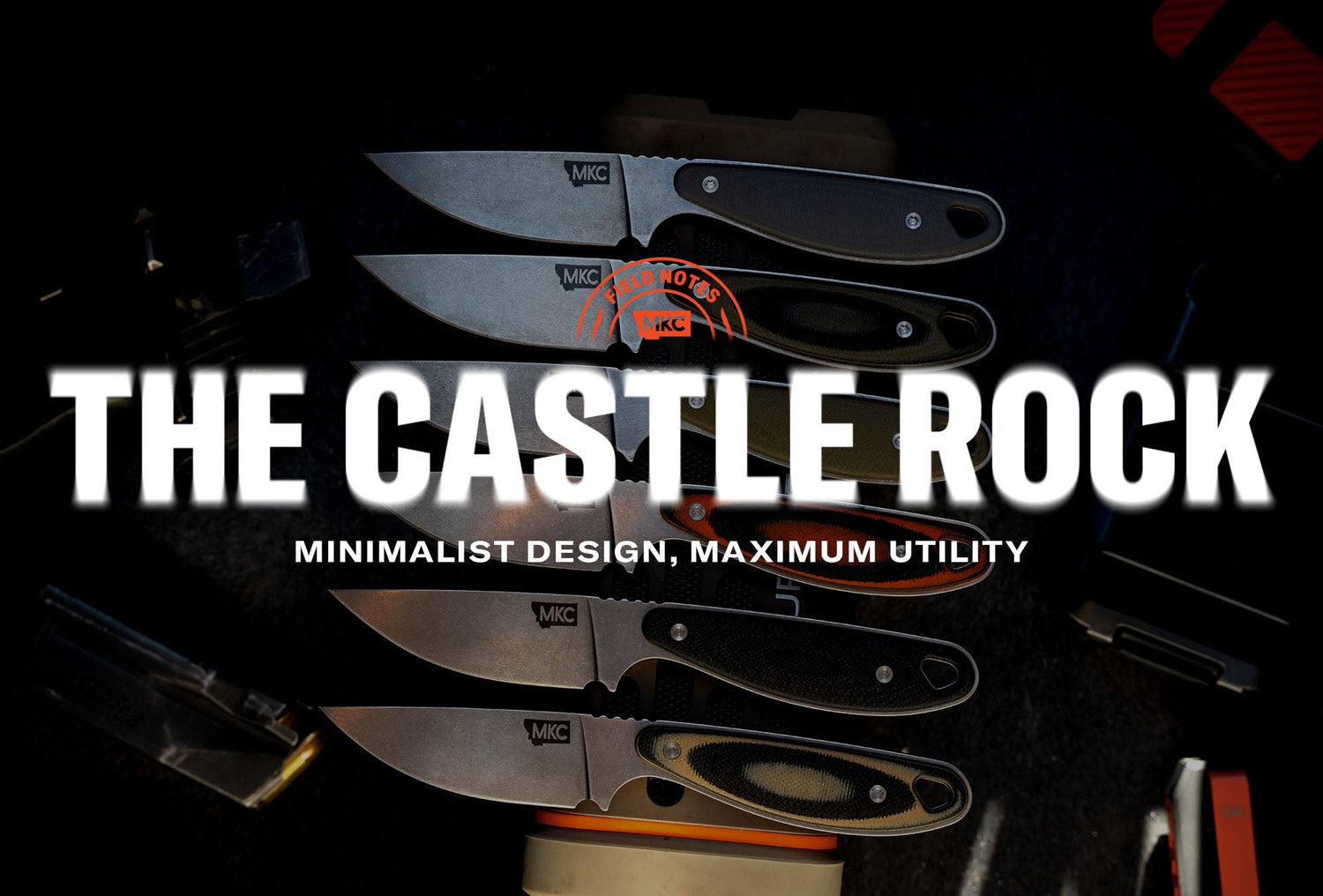 Six MKC knives displayed on a dark surface, including the Castle Rock fixed blade with its clean, minimalist profile.
