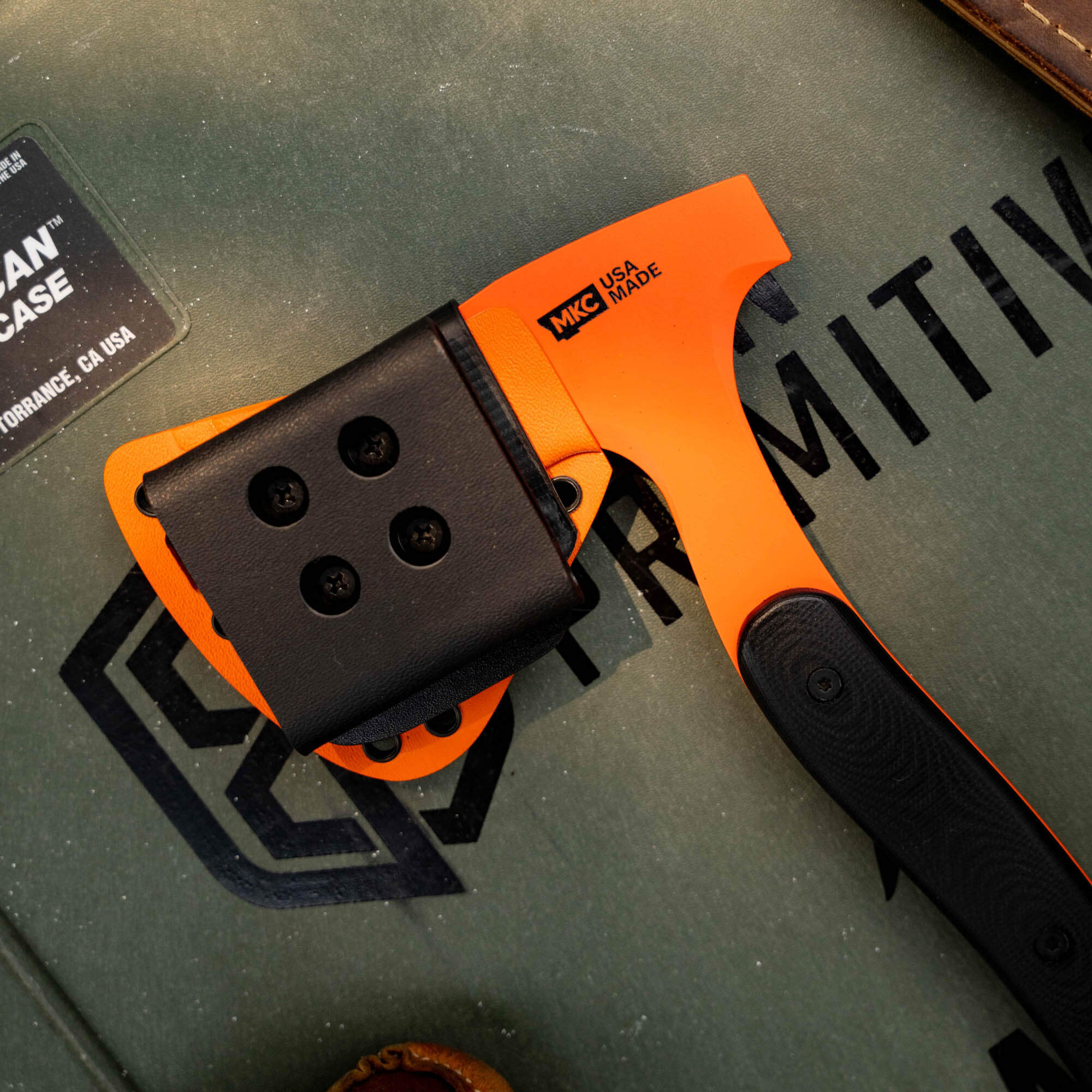 Additional Kydex sheath for the Hellgate Hatchet, featuring a bright orange handle and secure attachment points.