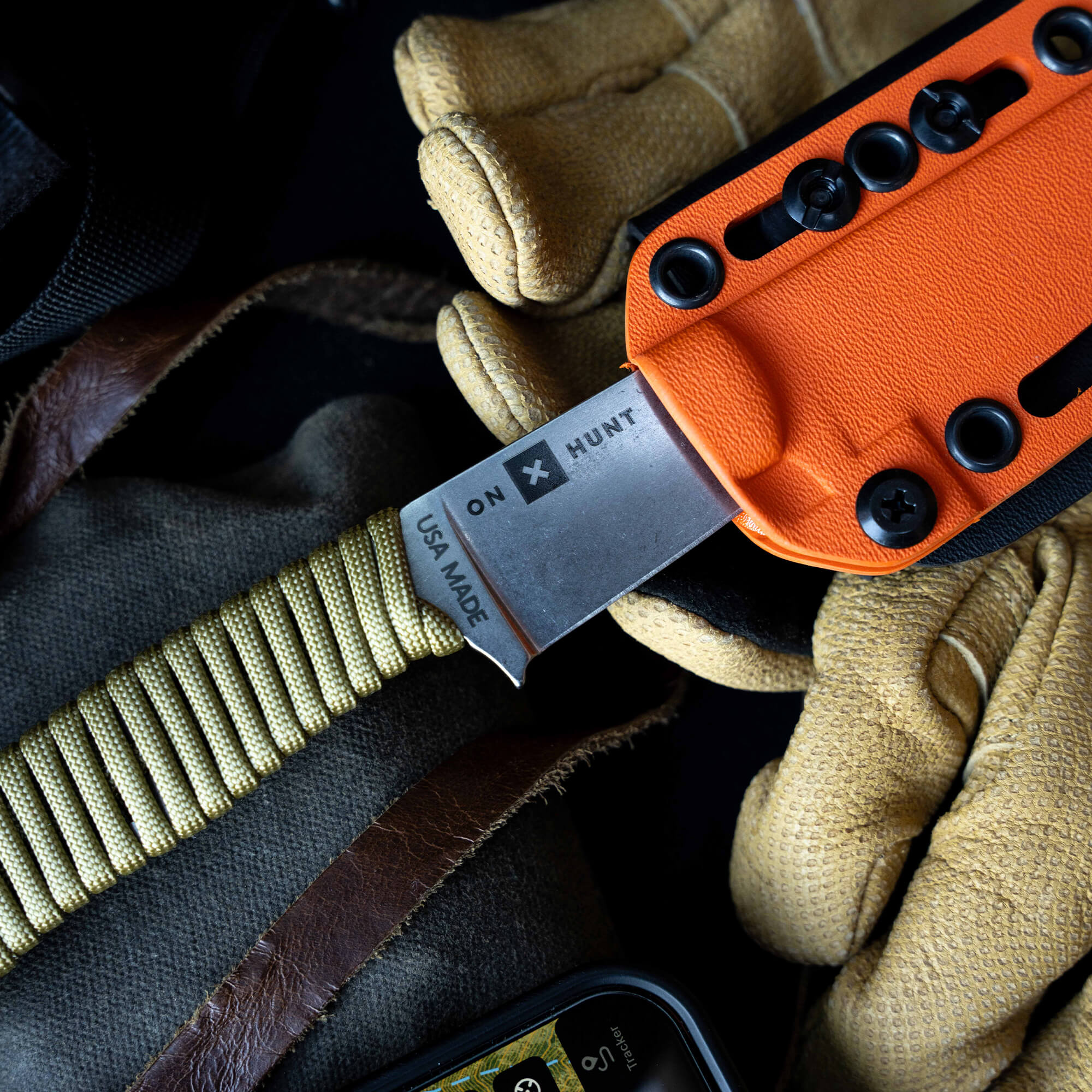 ONX Hunt Magnacut Speedgoat 2.0 knife with orange handle, surrounded by gloves and gear, showcasing its rugged design.