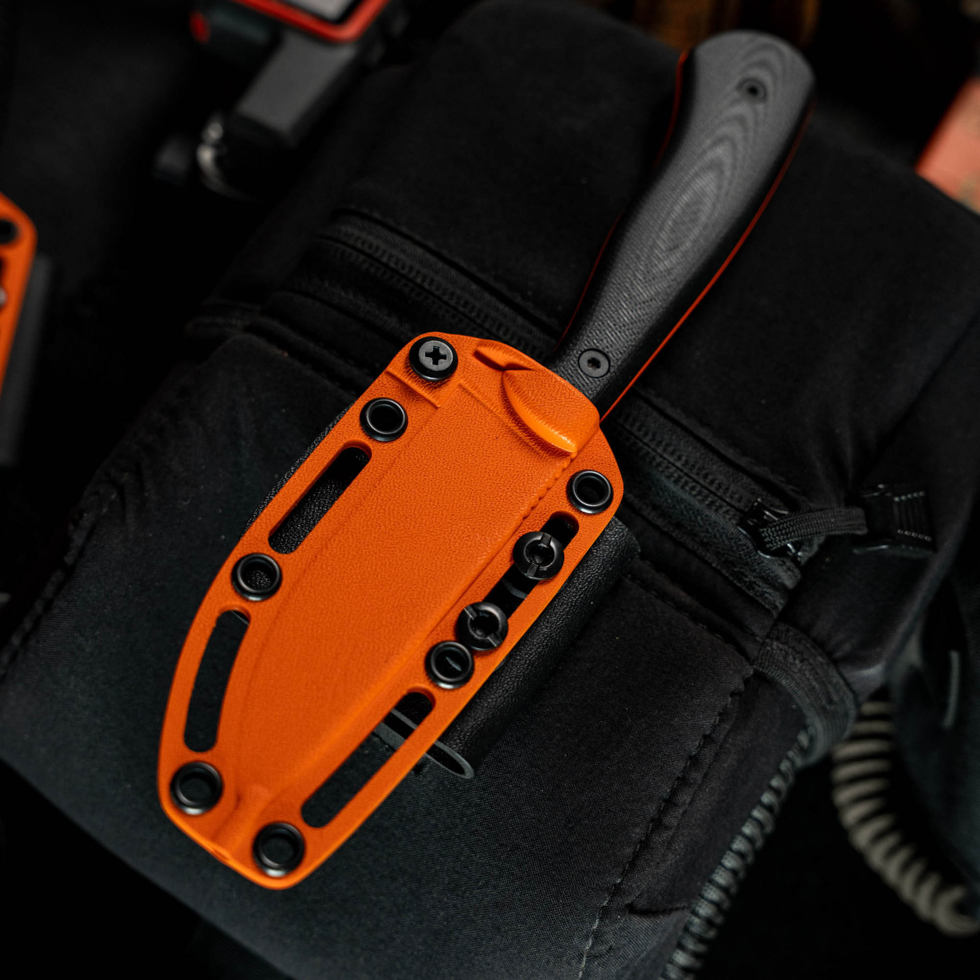 Kydex sheath for the Whitetail knife, featuring a vibrant orange color and secure mounting options for easy carry.