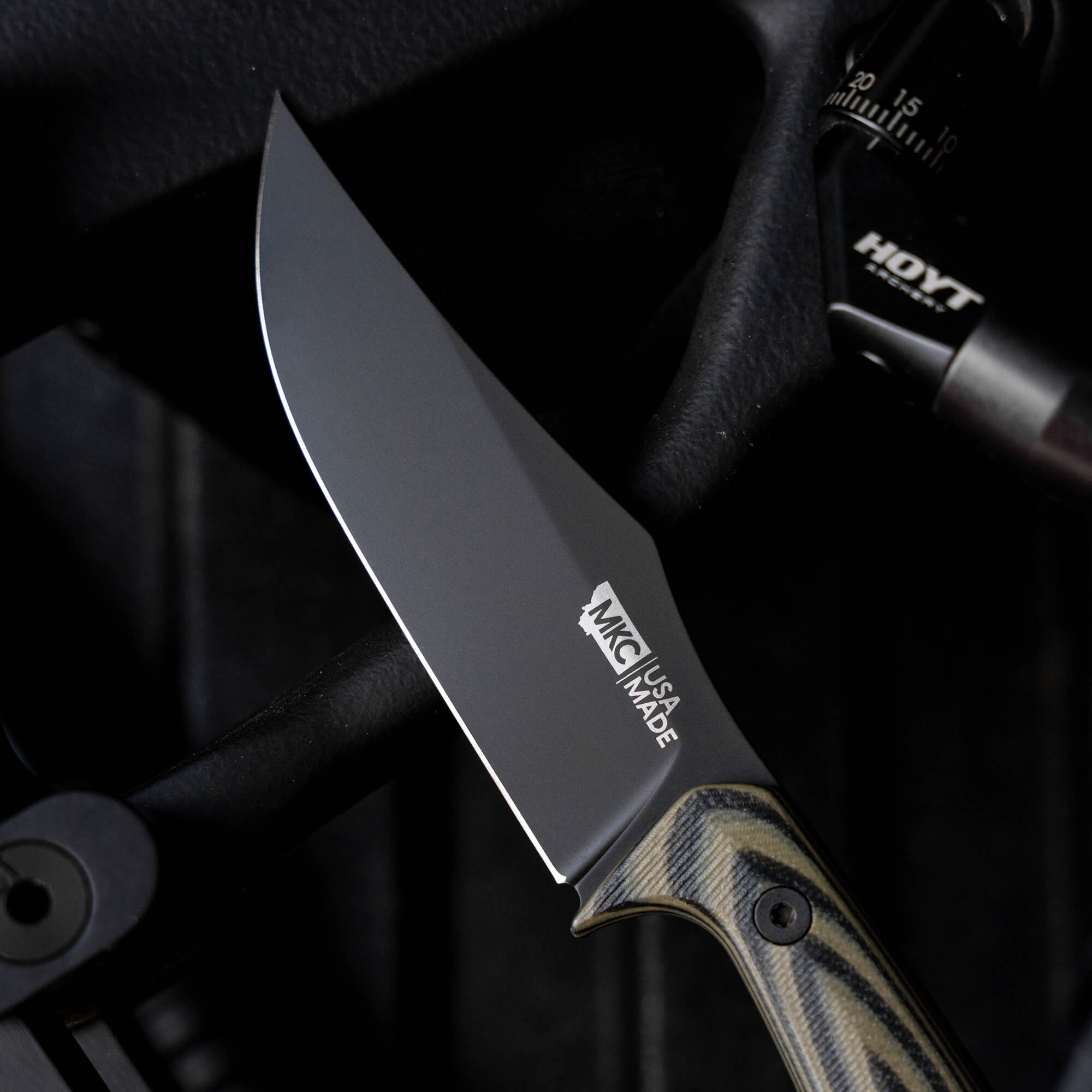Close-up of the NOCK ON Triumph Pro knife blade, showcasing its sleek design and textured handle, highlighting American craftsmanship.
