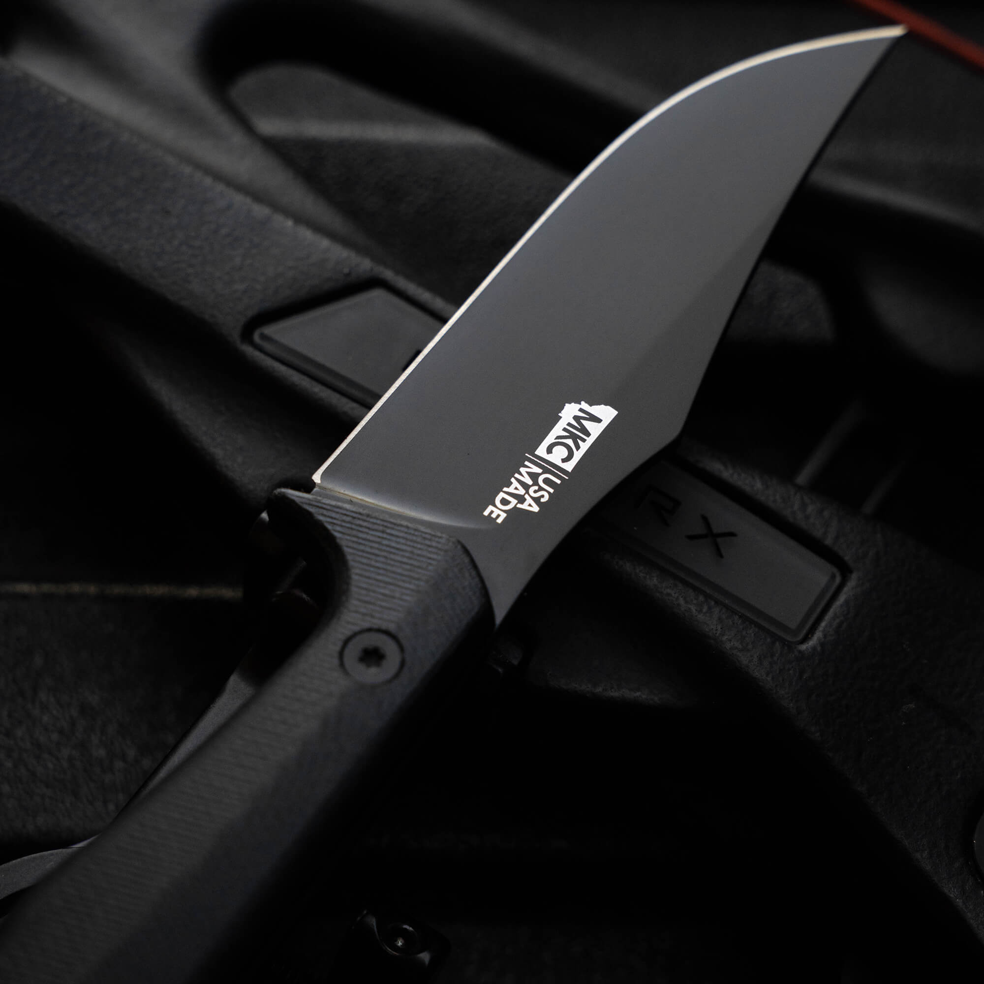 Montana Knife Company's Nock On Triumph Pro knife with a sleek black blade and ergonomic handle, showcasing quality craftsmanship.