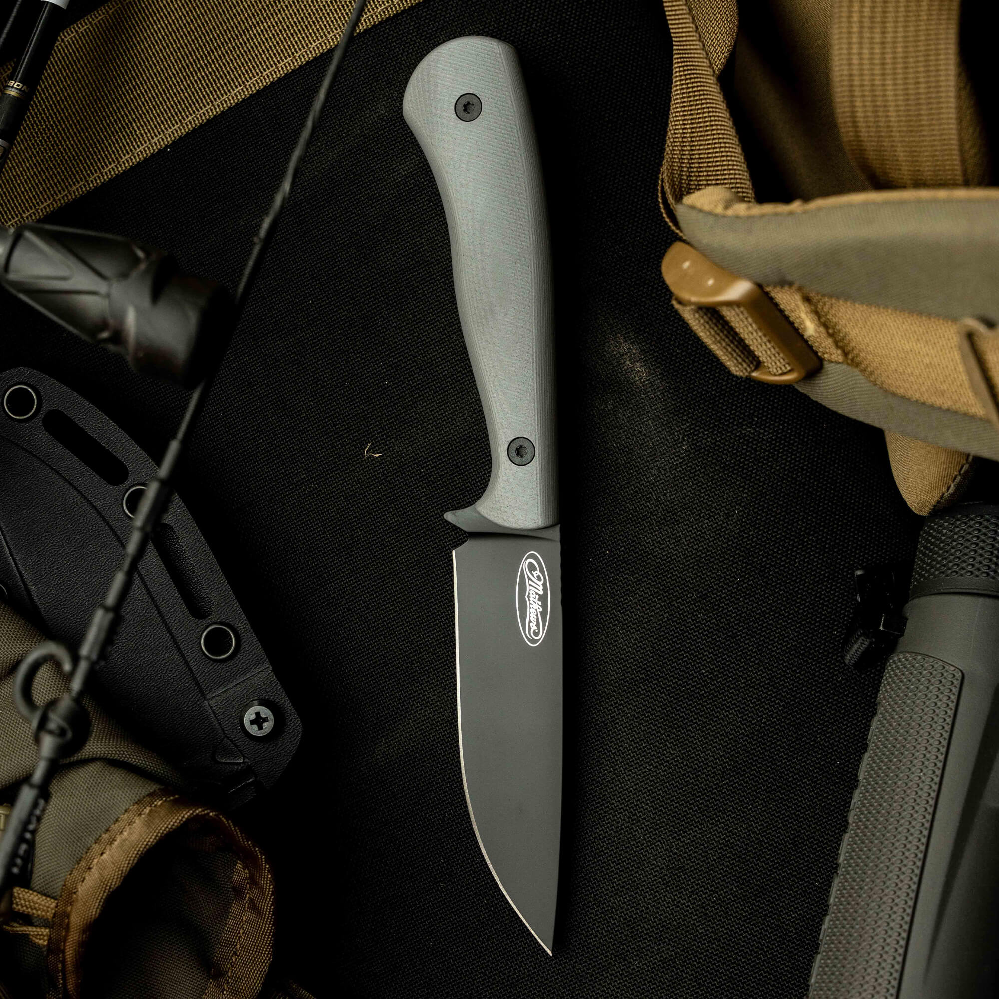 Mathews Archery MKC Whitetail knife with a sleek black blade and gray handle, ideal for hunting and outdoor use.