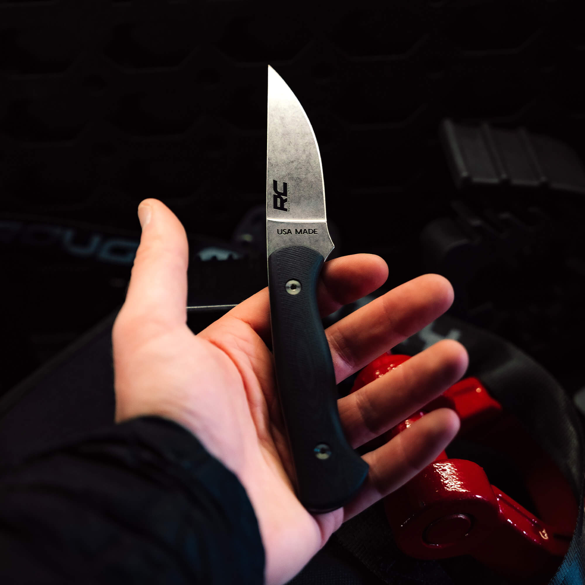 Hand holding the Rough Country Magnacut Blackfoot 2.0 knife, showcasing its sleek blade and ergonomic handle.