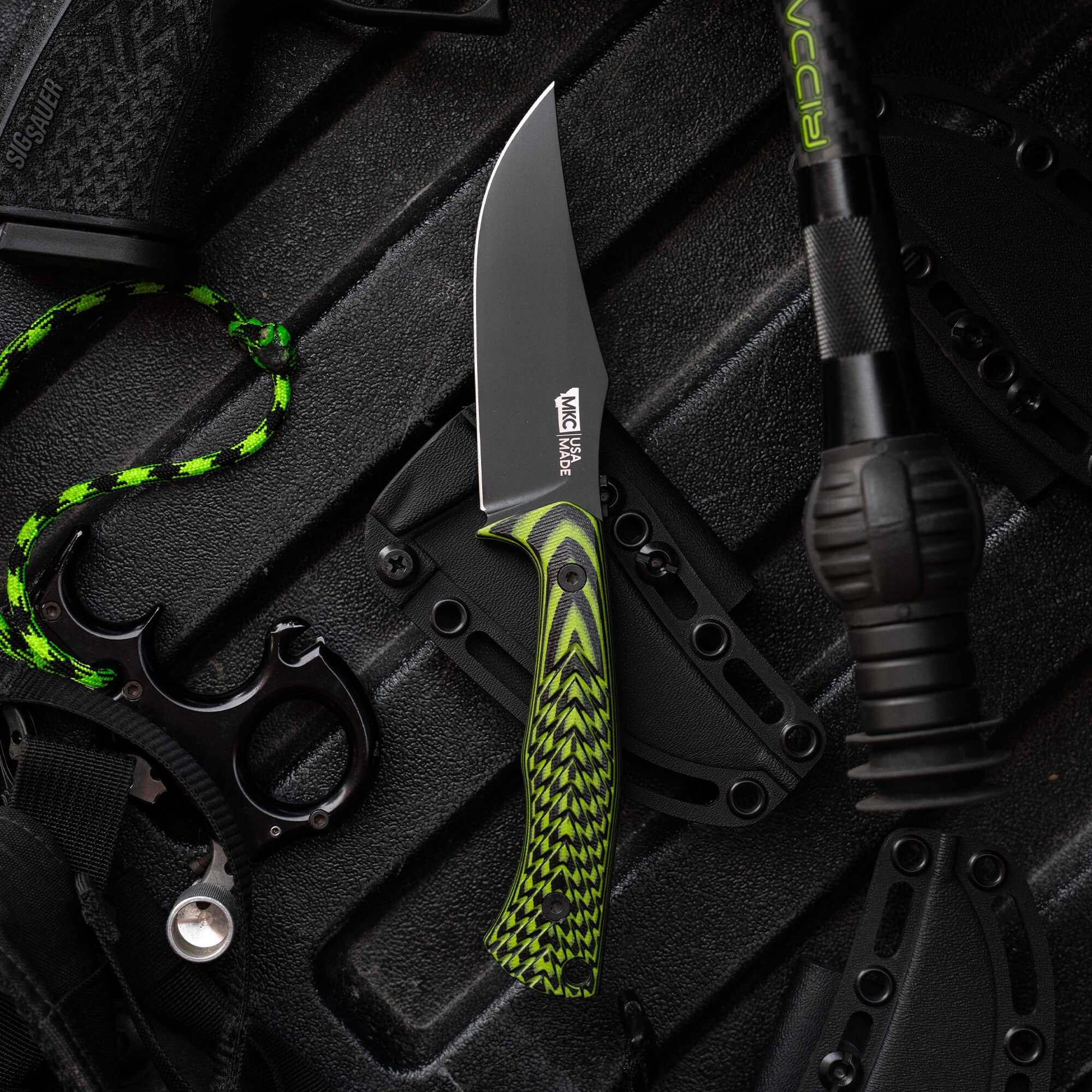 Montana Knife Company's Nock On Triumph Pro knife features a sleek black blade and vibrant green handle, designed for outdoor use.